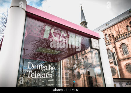 Freiburg im Breisgau, Germania - 31 dicembre 2017: Deutsche Telekom phone booth davanti a una chiesa nel centro storico della città in un giorno di inverno Foto Stock