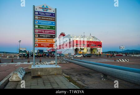 L'Italia, Sardegna, Olbia, 2014-04-14: Porto di Olbia sull isola di Sardegna al tramonto con signpost traghetto e preparazione per la partenza Foto Stock