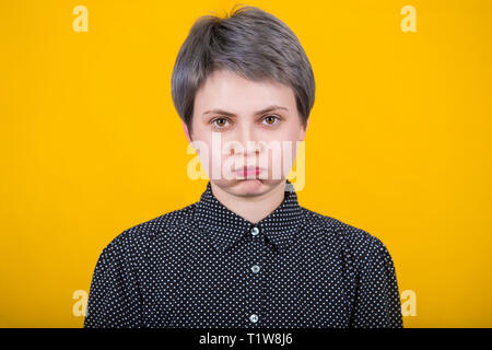 Infastiditi irritato giovane femmina hipster soffiando la sua guance, accigliata, sensazione di stanchezza o frustrato con qualcosa. Le espressioni facciali umane, le emozioni di un Foto Stock