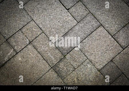 La strada sul marciapiede in pietra naturale è rivestito con mosaici di colore grigio chiaro .Texture.Background. Foto Stock