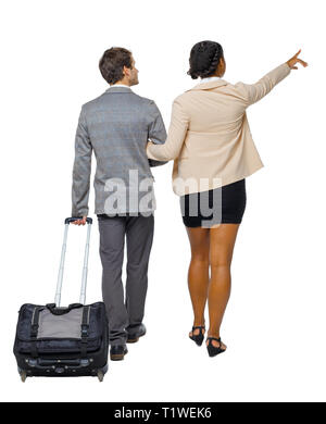 Vista posteriore di puntamento di interracial andando giovane con la valigia. Vista posteriore di raccolta persone. vista posteriore di persona. Isolato su sfondo bianco. Hu Foto Stock