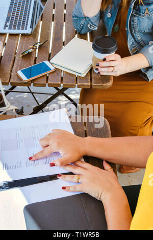 Vista dall'alto di due femmine aventi una riunione aziendale presso una caffetteria in una giornata di sole Foto Stock