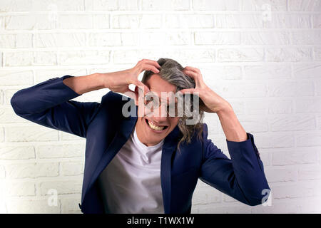 Ritratto di elegante imprenditore con ricci capelli lunghi in occhiali da sole sorride alla fotocamera su sfondo bianco. Mantiene la sua testa. Colpo del cervello Foto Stock