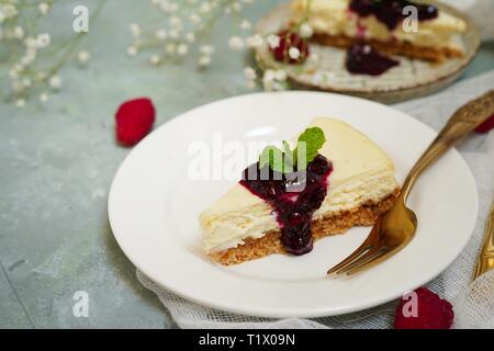 Fetta di Hmemade Cheesecake con Lampone Mirtillo salsa, il fuoco selettivo Foto Stock