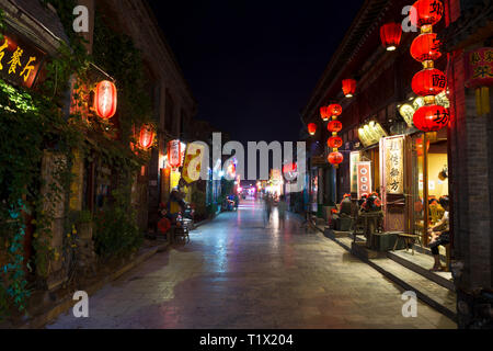 Di Pingyao, Cina - 08 14 2016: Case, luci in una strada di Pingyao. La vita notturna a Pingyao, Shanxi, Cina. La città antica di Pingyao è un famoso turi Foto Stock