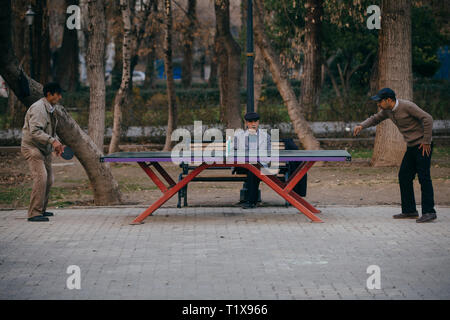 Gli uomini giocando a ping-pong in Tehran city park Foto Stock