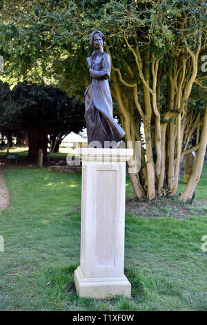 Statua di bronzo di Jane Austen (b.16 dicembre 1775-d.18 luglio 1817) da Adam Roud nella chiesa di St Nicholas sagrato, Chawton, vicino a Alton, HAMPSHIRE, Regno Unito. Foto Stock