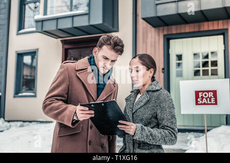 Imprenditore parlando di agente immobiliare in piedi fuori casa Foto Stock