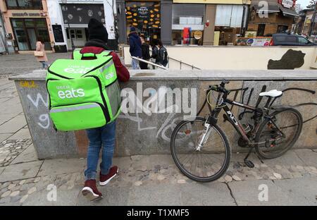Bucarest, Romania - Febbraio 07, 2019: Un Uber mangia il cibo corriere consegna riposa in San George Square a Bucarest, in Romania. Foto Stock