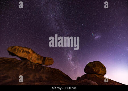Un uomo orologi un stellato cielo Africano in Zimbabwe. Foto Stock