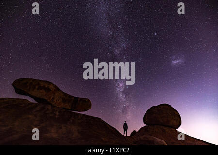 Un uomo orologi un stellato cielo Africano in Zimbabwe. Foto Stock