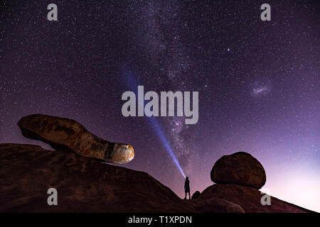 Un uomo orologi un stellato cielo Africano in Zimbabwe. Foto Stock