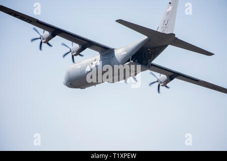 Un trentaseiesimo Airlift Squadron loadmaster onde per gli equipaggi di terra dal retro di un C-130J Super Hercules durante la Yokota C-130J Rodeo Marzo 22, 2019, a Yokota Air Base, Giappone. Il concorso consisteva di sei eventi in esecuzione e la precisione dei vari velivoli di carico, scarico e operazioni di volo. (U.S. Air Force foto di Senior Airman Donald Hudson) Foto Stock