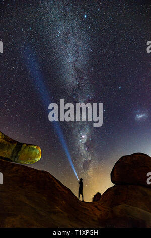Un uomo orologi un stellato cielo Africano in Zimbabwe. Foto Stock