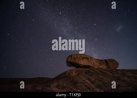 Un uomo orologi un stellato cielo Africano in Zimbabwe. Foto Stock
