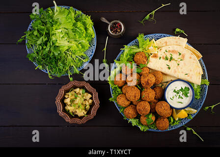 Falafel hummus e pita. Medio orientale o piatti arabi su uno sfondo scuro. Cibo Halal. Vista dall'alto. Spazio di copia Foto Stock