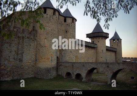 Cité de Carcassonne, Aude, Occitanie, Francia: Château Comtal (Conte il castello e il ponte sopra il fossato asciutto. Cité de Carcassonne è la più grande città in Europa con le sue mura ancora intatte. Foto Stock