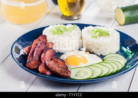 La carne di maiale tocino con riso e uova fritte. Piatto filippino Foto Stock