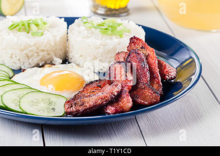 La carne di maiale tocino con riso e uova fritte. Piatto filippino Foto Stock