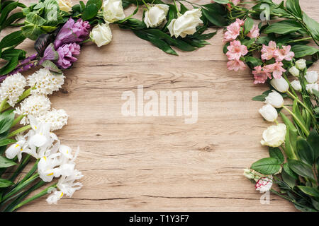 Vista dall'alto di freschi fiori colorati su una superficie di legno Foto Stock