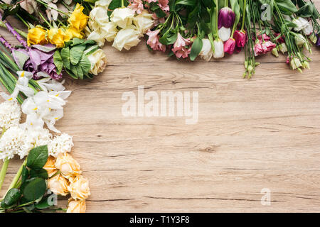 Vista dall'alto di freschi fiori colorati su una superficie di legno Foto Stock