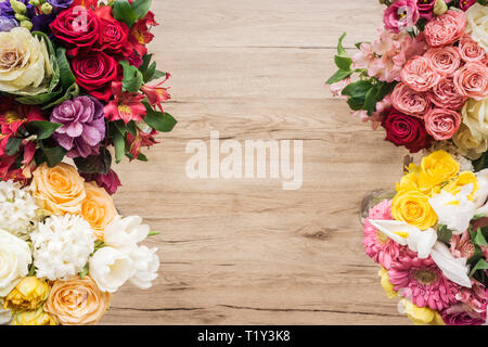 Vista dall'alto di freschi fiori colorati su una superficie di legno Foto Stock