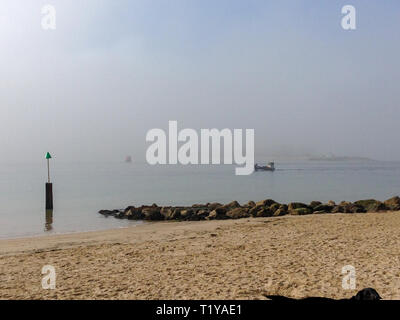 Poole, Dorset, Regno Unito. 29 marzo, 2019. Foschia mattutina per le persone e i cani a camminare e correre sulla spiaggia. Credito: Suzanne McGowan/Alamy Live News Foto Stock