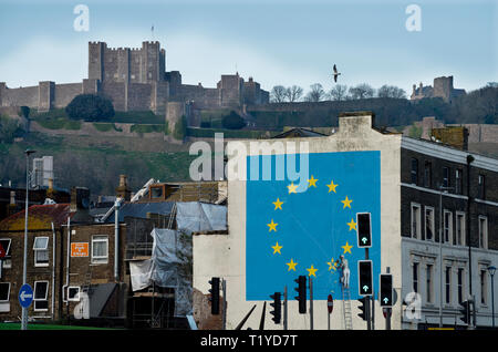 Dover, Kent, Inghilterra, Regno Unito. 28 Mar, 2019. Il Brexit ispirato murale di artista Banksy su un edificio sotto il Normanno il castello di Dover seduta alta sopra il porto dei traghetti sulle bianche scogliere. Credito: BRIAN HARRIS/Alamy Live News Foto Stock