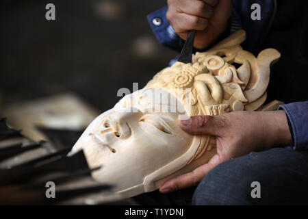 Anshun, Cina. 29 mar 2019. Zhou Ming, un ereditiere di sculture in legno di Anshun, scolpisce in una maschera di Dixi in Anshun, a sud-ovest della Cina di Guizhou, 28 marzo 2019. Dixi, un locale opera in Anshun, è stato elencato come uno dei national immateriali del patrimonio culturale nel 2006. Nel villaggio Zhouguan, c'è una troupe Dixi dotate di membri da adolescente a octogenarian. Le prestazioni di una secolare troupe è popolare tra gli abitanti dei villaggi locali. Credito: Xinhua/Alamy Live News Foto Stock