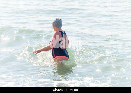 Aberystwyth, Galles. 29 mar 2019. Regno Unito - previsioni del tempo - Un senior donna nuota da sola in mare nel caldo sole primaverile, (ma mantiene la sua wooly hat su!), in Aberystwyth, il Cardigan Bay costa del Galles occidentale. Alta pressione continua a dominare il meteo per molto di Inghilterra e Galles, con si stabilirono le condizioni meteo per durare almeno un altro giorno , prima di più condizioni dello scambiatore di calore di ritorno. Foto:Keith Morris/Alamy Live News Foto Stock