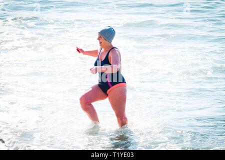 Aberystwyth, Galles. 29 mar 2019. Regno Unito - previsioni del tempo - Un senior donna nuota da sola in mare nel caldo sole primaverile, (ma mantiene la sua wooly hat su!), in Aberystwyth, il Cardigan Bay costa del Galles occidentale. Alta pressione continua a dominare il meteo per molto di Inghilterra e Galles, con si stabilirono le condizioni meteo per durare almeno un altro giorno , prima di più condizioni dello scambiatore di calore di ritorno. Foto:Keith Morris/Alamy Live News Foto Stock