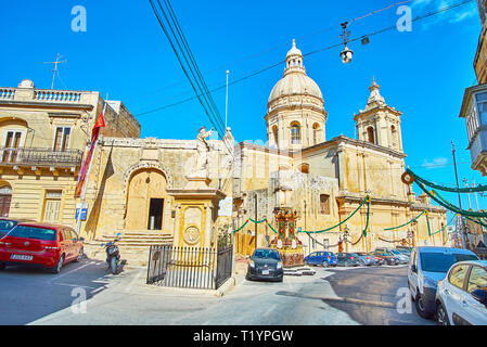 La vista sulla chiesa di St Nicholas dalla parete laterale con la statua del santo sul primo piano, Capoterra, Italia. Foto Stock