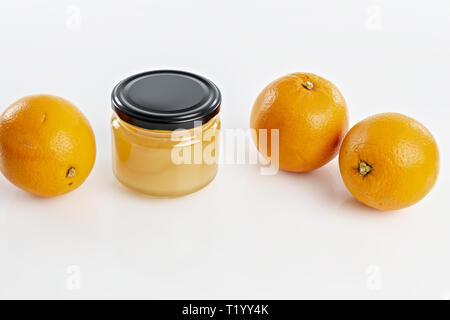 Miele all'arancio in vaso con arance Foto Stock