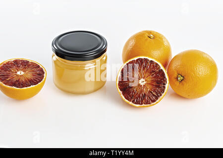 Miele all'arancio in vaso con arance tagliate Foto Stock