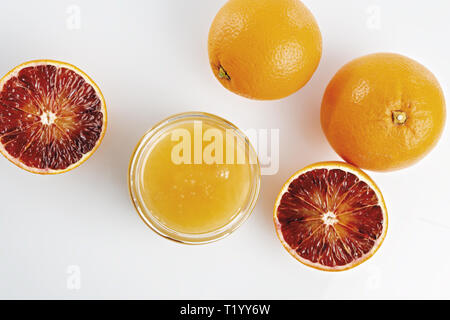 Miele all'arancio in vaso con arance tagliate dall'alto altra vista Foto Stock
