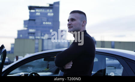 Imprenditore bello vicino alla sua auto in città Foto Stock