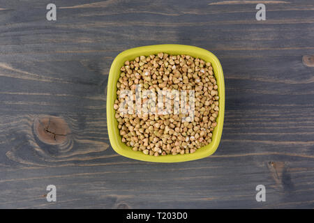 Naturale fresco verde Grano saraceno in vaso in ceramica su sfondo di legno. Vista superiore Foto Stock