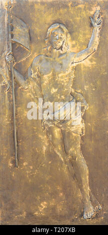 La figura di Gesù Cristo in bronzo in bassorilievo. Il Redentore contiene un flag nella sua mano. Ideale per i concetti e gli sfondi Foto Stock