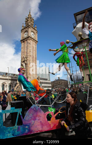 In Irlanda del Nord, Belfast, il giorno di San Patrizio parade passando l'Albert clock sull'angolo di High Street e Victoria Street. Foto Stock