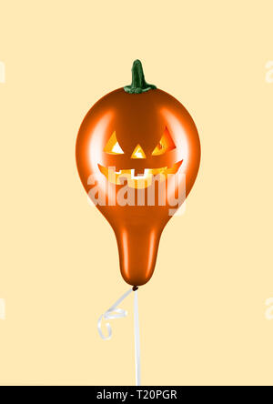 Festa di Halloween. Il design moderno. L'arte contemporanea collage. Oro palloncino formato zucca con candele all'interno contro la luce dello sfondo. Minimal Art. Lo spazio negativo per inserire il tuo testo. Foto Stock