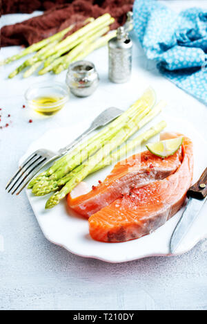 Materie di salmone e asparagi verdi su piastra Foto Stock