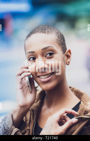 Una donna afro-brasiliana in Sao Paulo utilizzando il suo telefono in strada Foto Stock