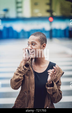 Una donna afro-brasiliana in Sao Paulo utilizzando il suo telefono in strada Foto Stock