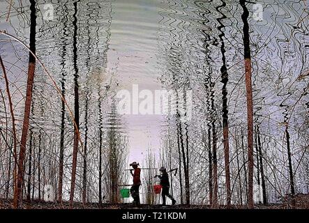 Pechino, Cina. 27 Mar, 2019. Foto scattata a Marzo 27, 2019 mostra una silhouette di agricoltori a camminare in un campo a Shanjiayu villaggio di Yiyuan County nella città di Zibo, est della Cina di Provincia dello Shandong. Credito: Zhao Dongshan/Xinhua/Alamy Live News Foto Stock