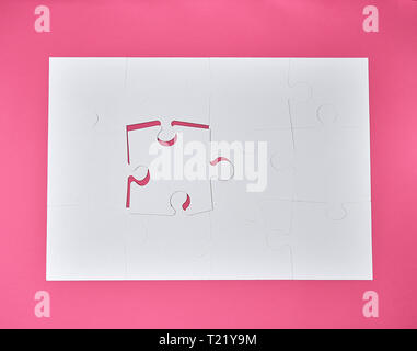 Bianco grande puzzle in bianco su sfondo rosa, vista dall'alto Foto Stock