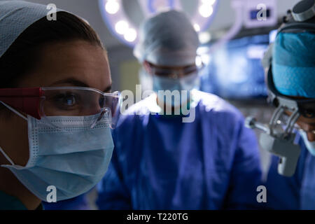 Chirurghi in sala operatoria durante un intervento chirurgico Foto Stock