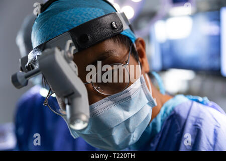 Il chirurgo in sala operatoria durante un intervento chirurgico Foto Stock