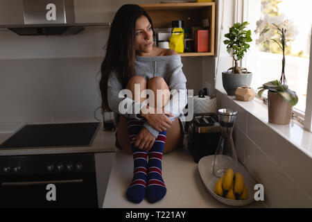 Bella donna rilassante in cucina a casa Foto Stock