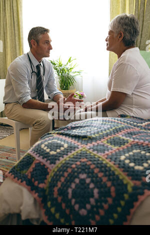 Medico maschio interagendo con i senior paziente femmina Foto Stock
