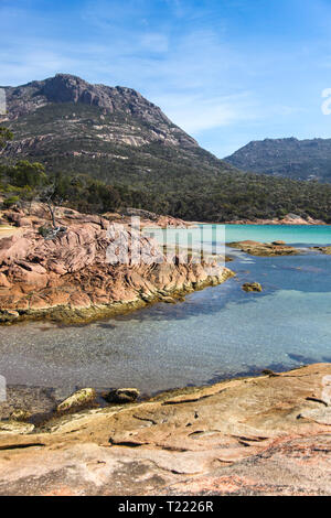 Vista sulla baia di luna di miele verso il 'Hazards' Mountain Range. La zona intorno a Coles Bay ha bella costa tra cui il ben noto vino Baia di vetro. Foto Stock